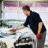 Man worker washing luxury car with sponge on a car wash