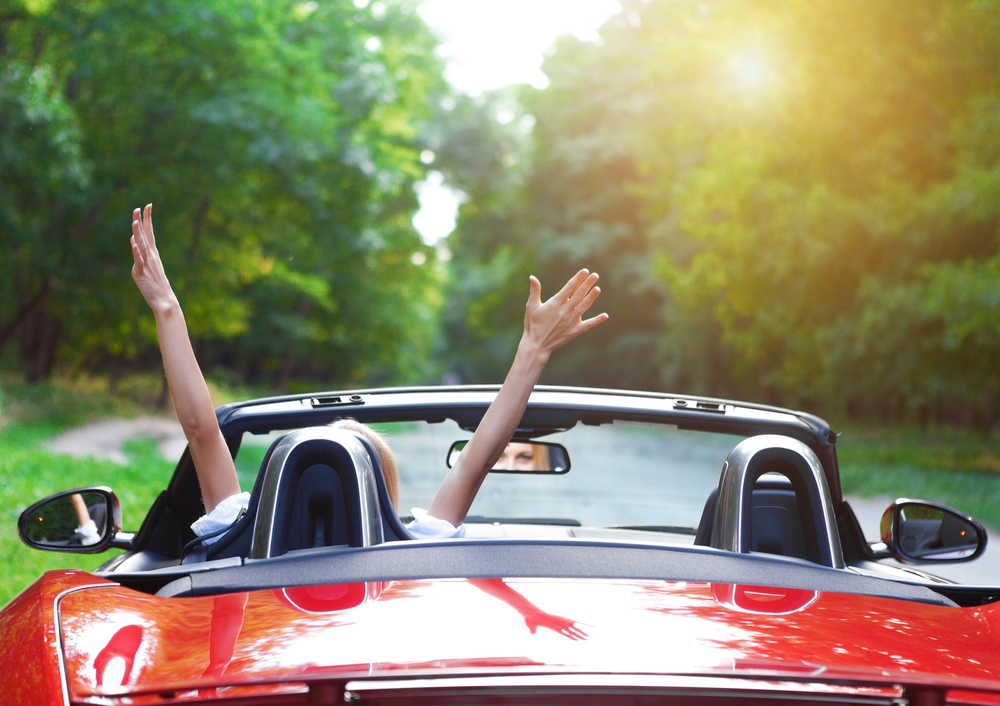 Beautiful blond young woman driving a sports car