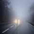 Dense fog on the country road, oncoming traffic